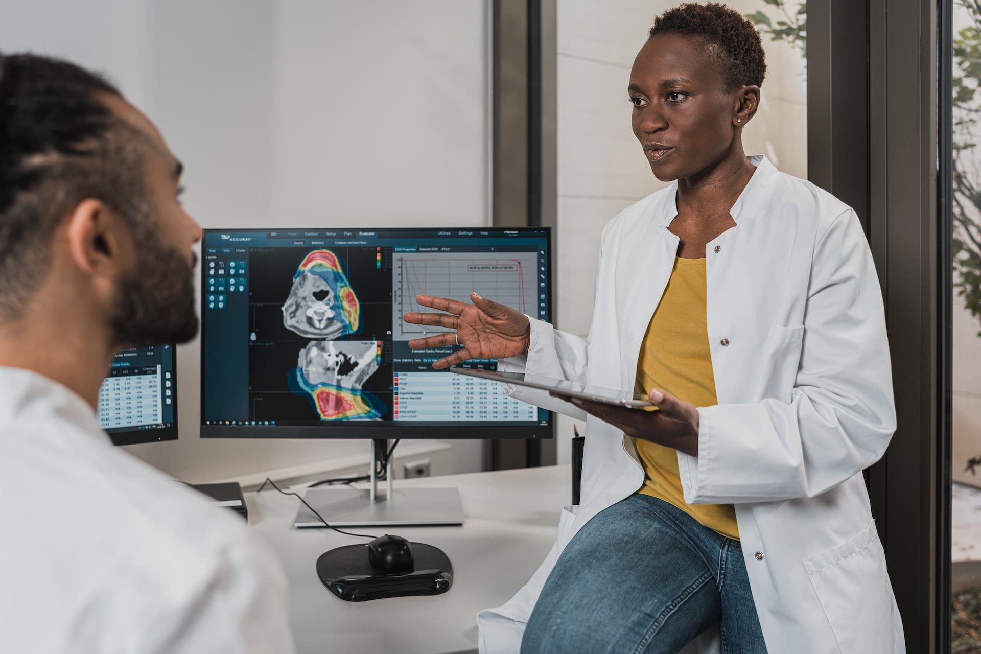 A doctor explaining a scan on a screen to a colleague