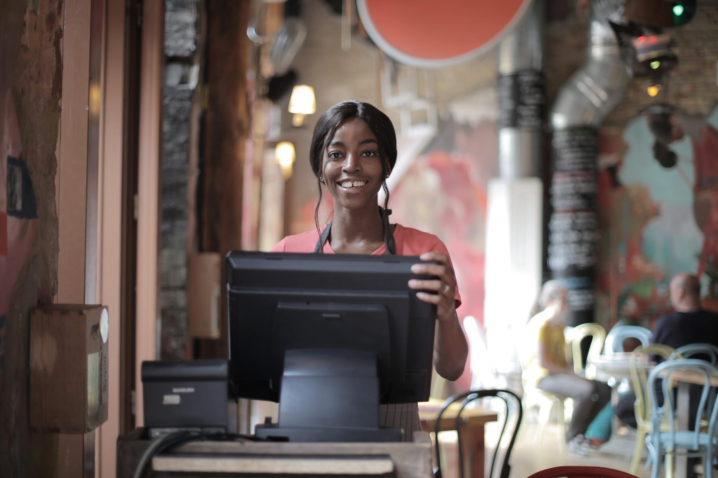 A smiling woman at the till of a shop